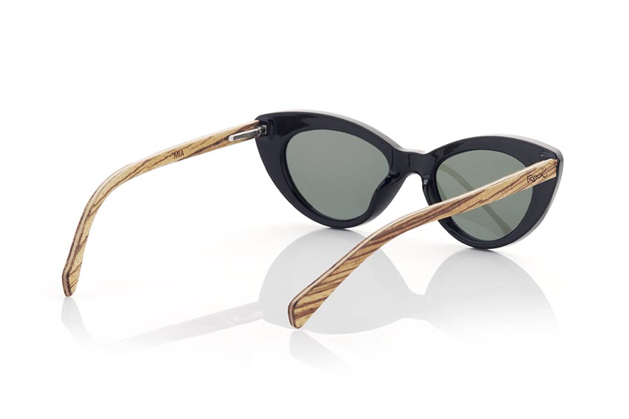 Wood eyewear of Walnut MIA. MIA sunglasses are an essential accessory for lovers of retro fashion. With their cat-eye design, these glasses are an ideal complement to achieve a sophisticated and timeless look. The satin black frame and walnut temples add elegance and sophistication to your look. and its green gradient lenses, in addition to protecting your eyes and skin, add a personal touch of color to the outfit. Without a doubt, MIA glasses are a must-have for any woman looking for a chic and timeless look. Front measurement 145x45mm Caliber: 50 for Wholesale & Retail | Root Sunglasses® 